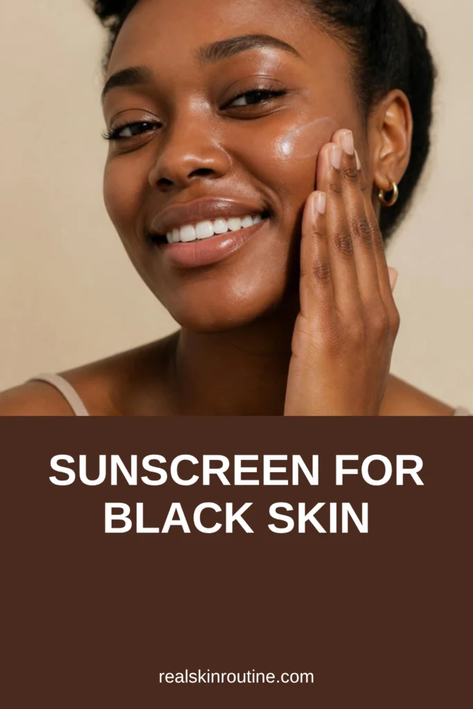 Woman with deep brown skin smoothing sheer sunscreen onto her cheek, pin for sunscreen for black skin