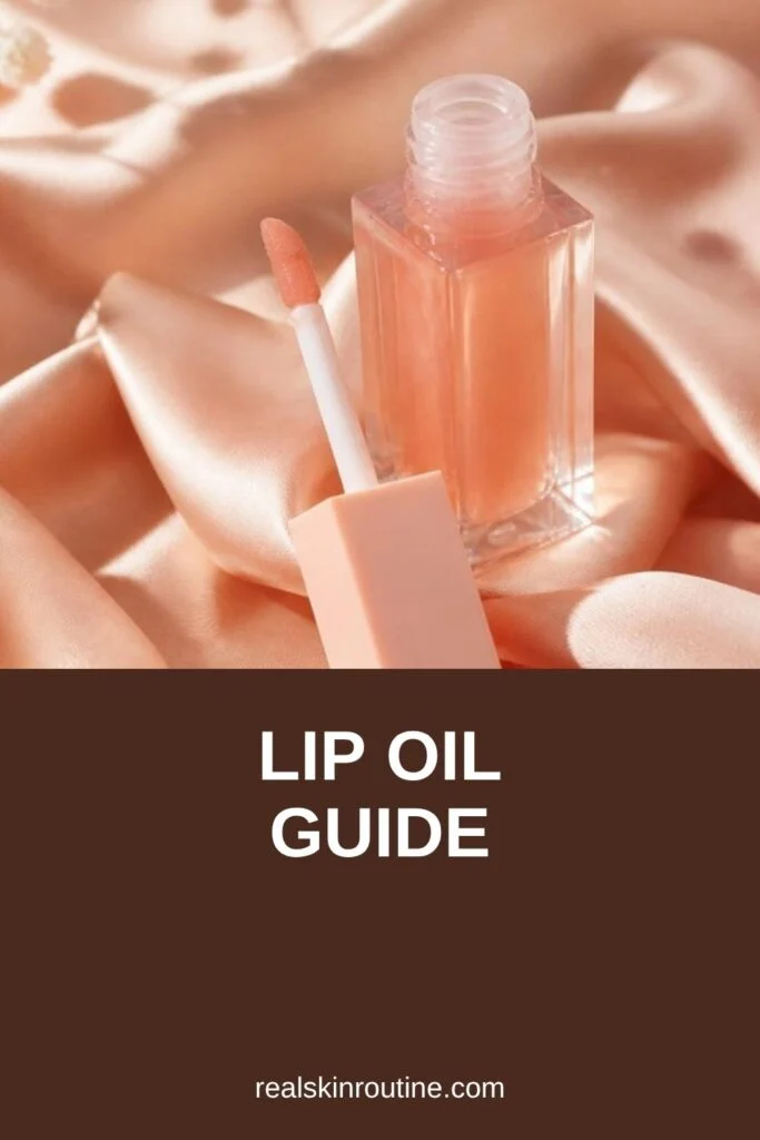 Glass lip oil bottle with a doe-foot applicator on a peach silk cloth, pin for lip oil
